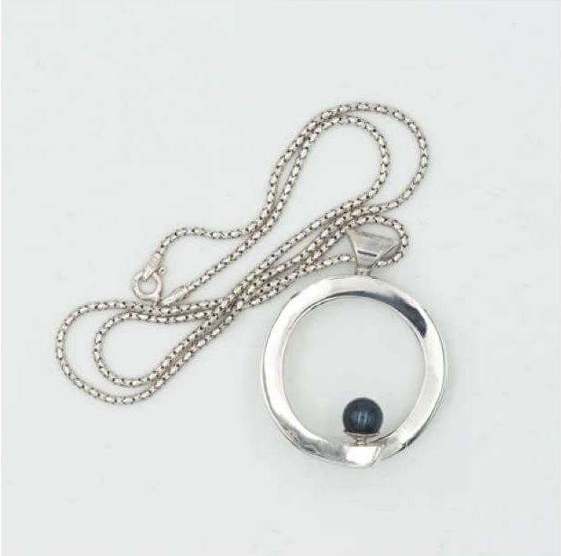 Image of silver pendant in a circle with a black pearl